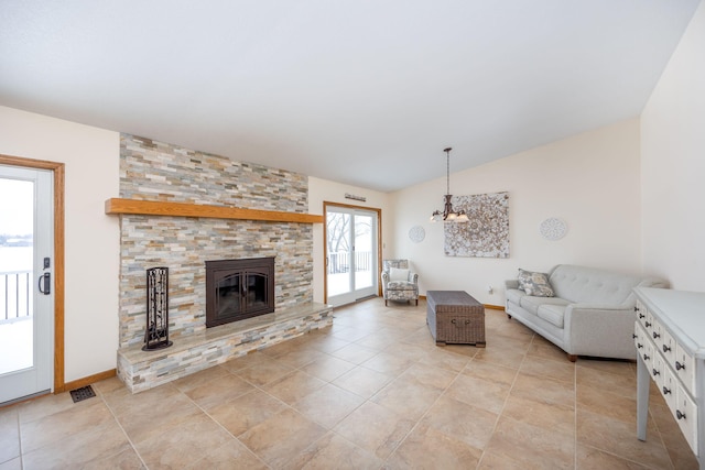 unfurnished living room featuring vaulted ceiling, a stone fireplace, and light tile patterned floors