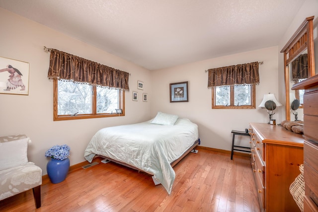 bedroom featuring light hardwood / wood-style flooring and multiple windows