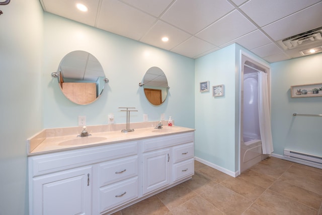 bathroom with a paneled ceiling, bathing tub / shower combination, a baseboard heating unit, and vanity