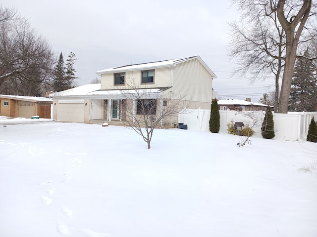 view of front facade with a garage and fence