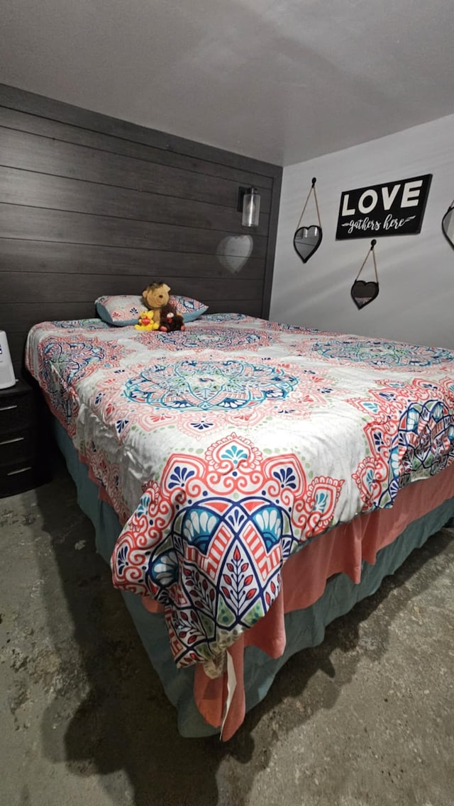 carpeted bedroom featuring wood walls