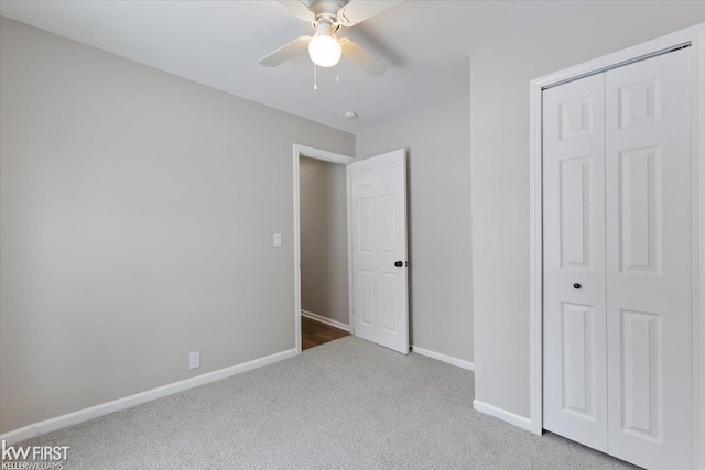 unfurnished bedroom with ceiling fan, carpet, and a closet