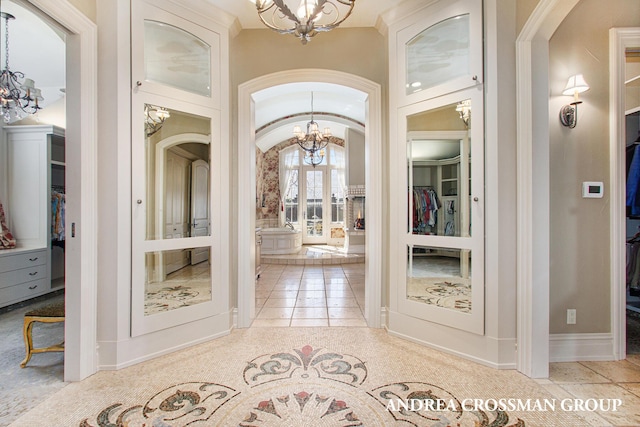 tiled entrance foyer with a chandelier and lofted ceiling