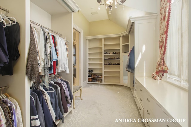 walk in closet featuring vaulted ceiling and light carpet