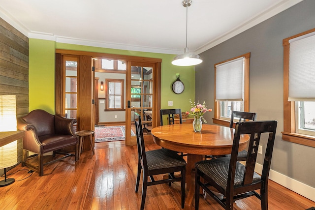 dining space featuring wood-type flooring and ornamental molding