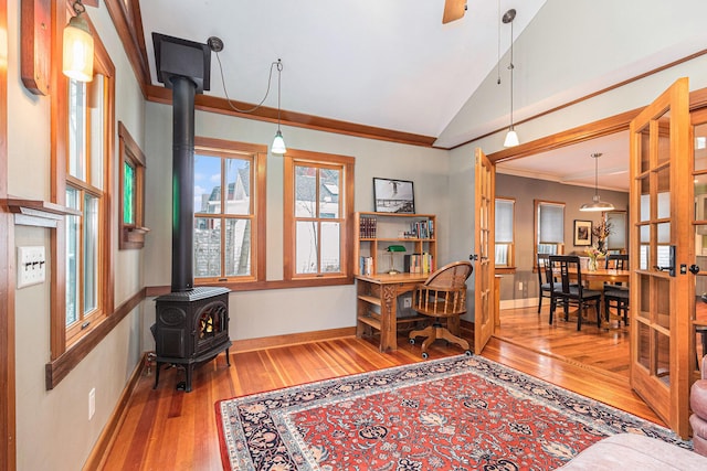 office space featuring ornamental molding, hardwood / wood-style floors, a wood stove, and lofted ceiling