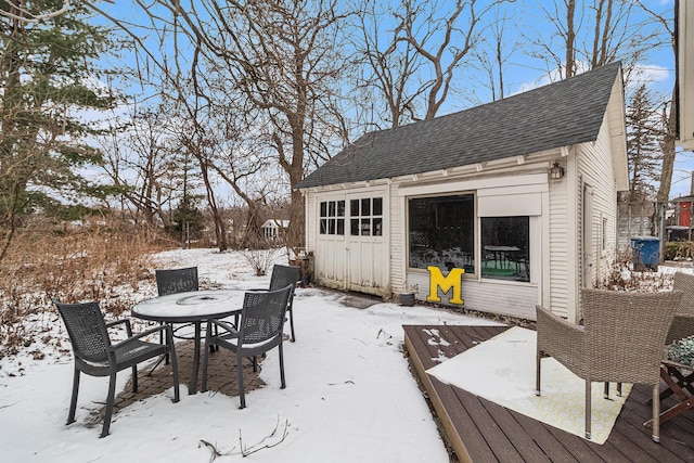 snow covered deck featuring an outbuilding