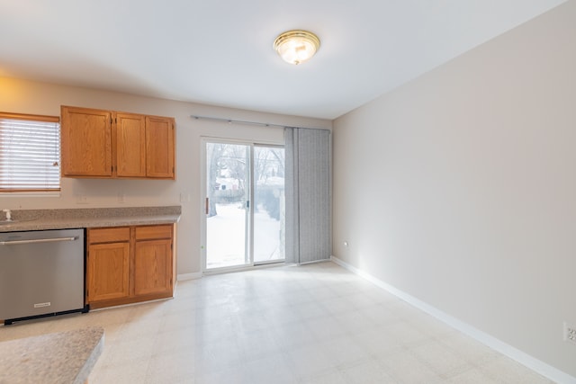 kitchen featuring dishwasher, light countertops, light floors, and baseboards