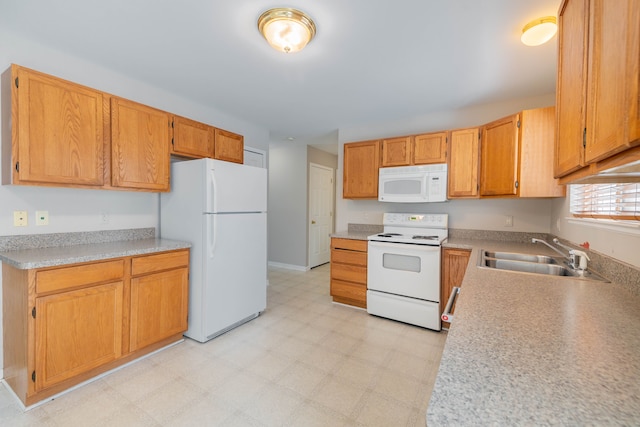 kitchen featuring white appliances, light countertops, a sink, and light floors