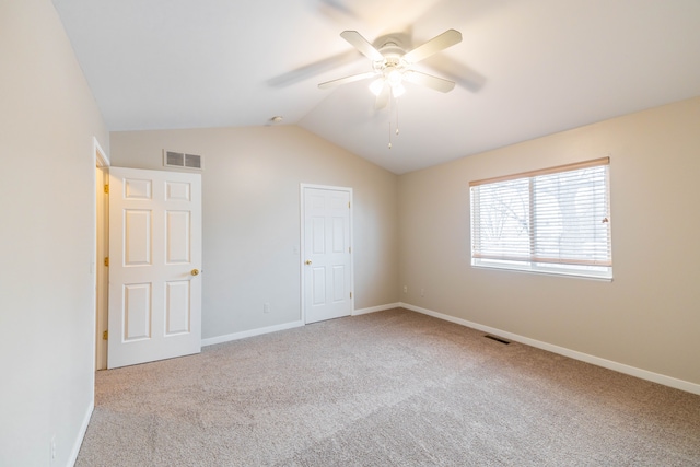 unfurnished bedroom with visible vents, baseboards, vaulted ceiling, and carpet flooring