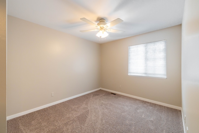 unfurnished room with a ceiling fan, carpet flooring, visible vents, and baseboards