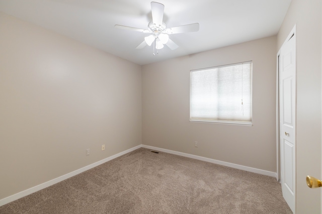 unfurnished room with light colored carpet, ceiling fan, visible vents, and baseboards