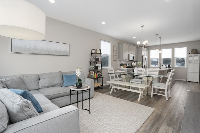 living room featuring dark wood-style floors, recessed lighting, and an inviting chandelier