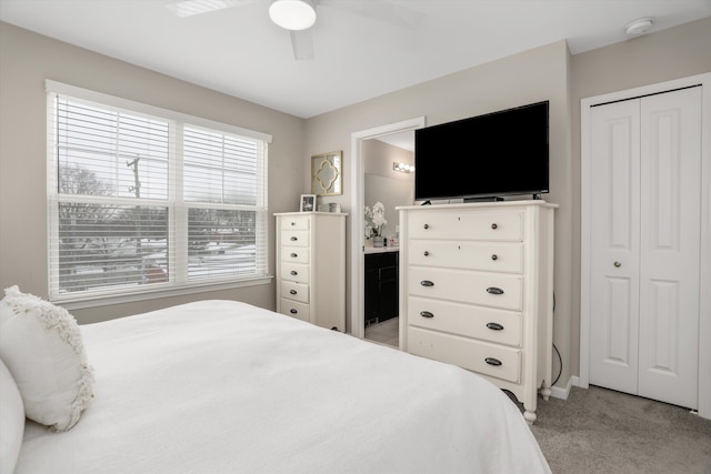 bedroom with ceiling fan, a closet, connected bathroom, and light colored carpet