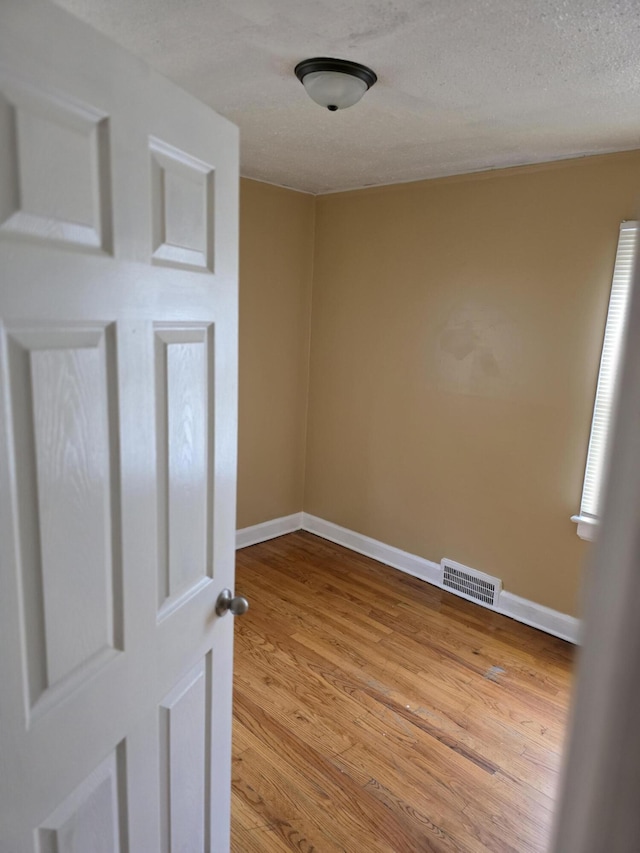 20529 Irvington St, Highland Park, MI 48203 - empty room with baseboards, wood finished floors, visible vents, and a textured ceiling