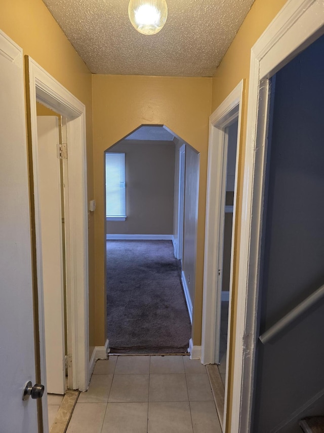 20529 Irvington St, Highland Park, MI 48203 - hallway featuring baseboards, tile patterned floors, a textured ceiling, and carpet
