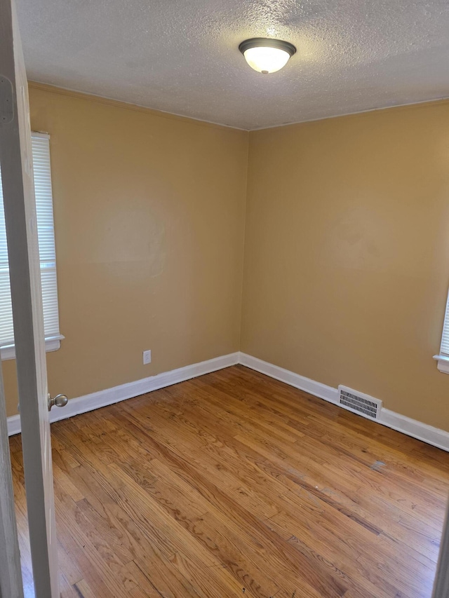 20529 Irvington St, Highland Park, MI 48203 - unfurnished room featuring baseboards, wood finished floors, visible vents, and a textured ceiling
