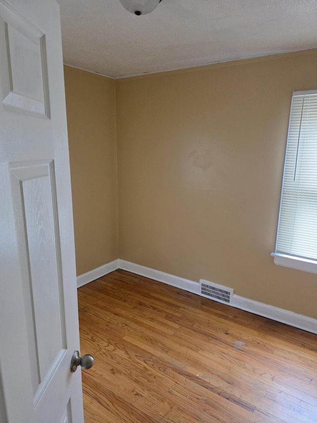 20529 Irvington St, Highland Park, MI 48203 - spare room featuring baseboards, wood finished floors, and visible vents