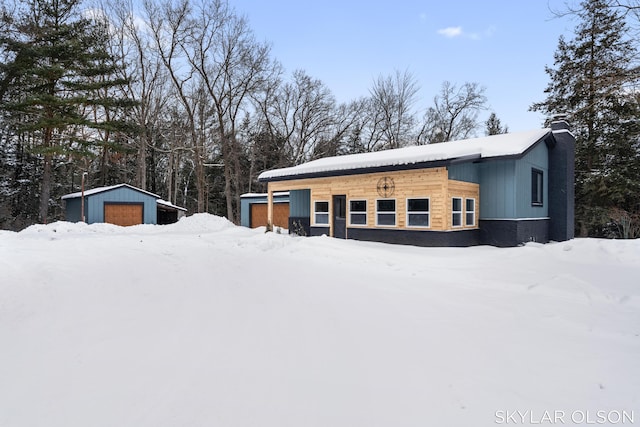 view of front of house featuring a garage and an outbuilding