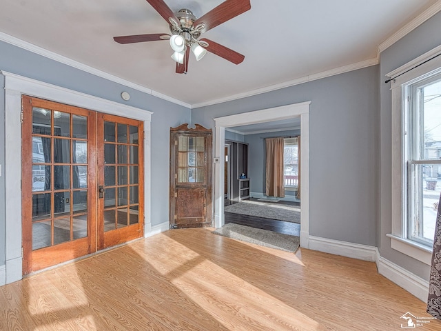 spare room with hardwood / wood-style flooring, plenty of natural light, french doors, and ornamental molding