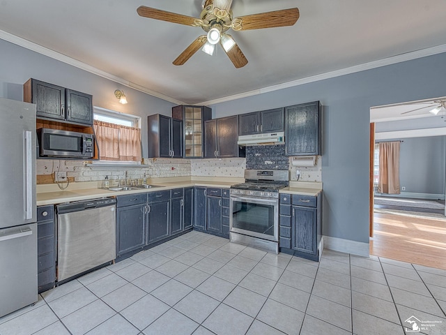 kitchen featuring appliances with stainless steel finishes, sink, light tile patterned floors, and ornamental molding