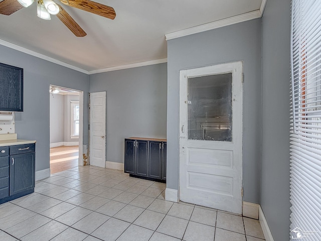 interior space with ornamental molding, ceiling fan, and light tile patterned floors