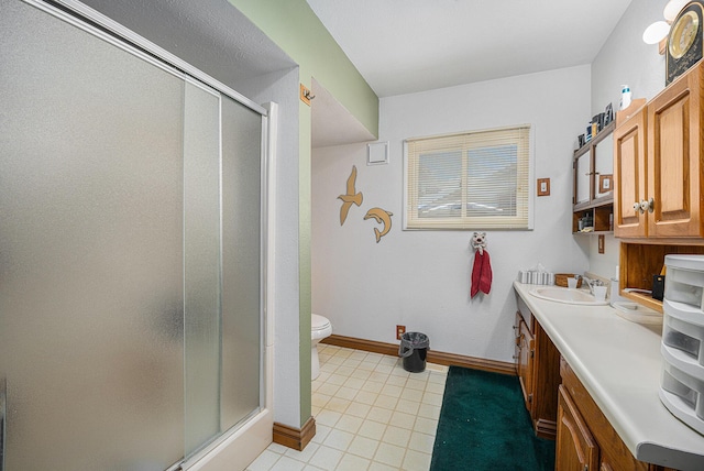 bathroom featuring toilet, tile patterned floors, an enclosed shower, and vanity