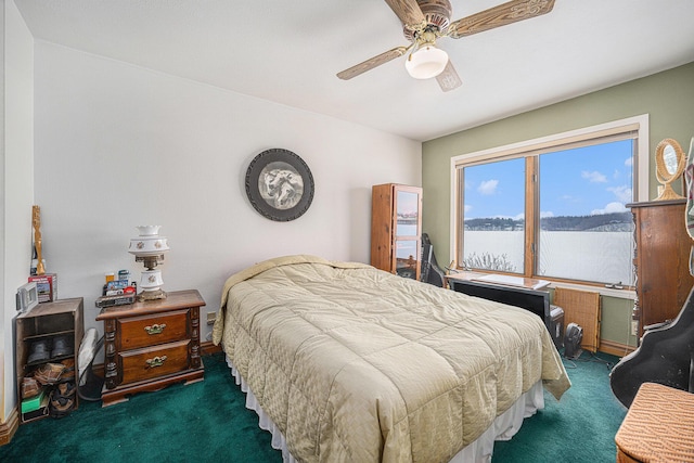 carpeted bedroom featuring a water view and ceiling fan