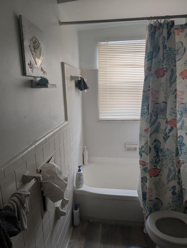 bathroom with wood-type flooring, tile walls, toilet, and shower / bath combination with curtain