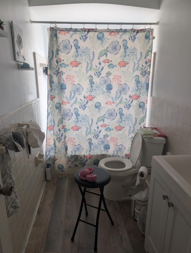 full bathroom featuring toilet, tile walls, vanity, and wood-type flooring