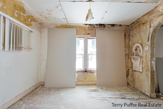 spare room featuring arched walkways