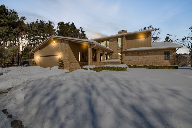 view of front of home featuring an attached garage and brick siding