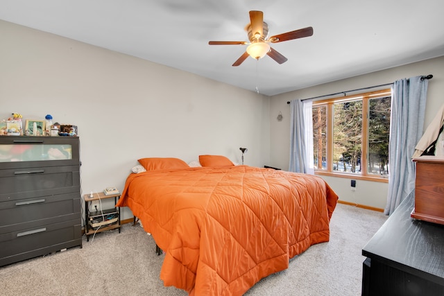 bedroom with a ceiling fan, light colored carpet, and baseboards