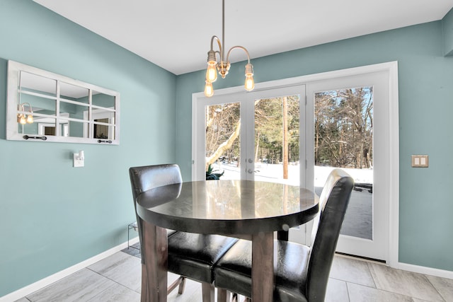 dining room featuring a chandelier, french doors, and baseboards