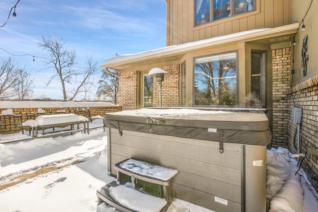 snow covered patio with a hot tub