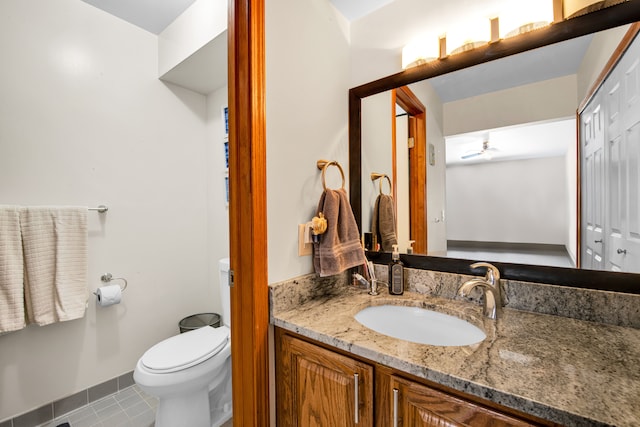 bathroom featuring tile patterned flooring, toilet, vanity, a ceiling fan, and a closet