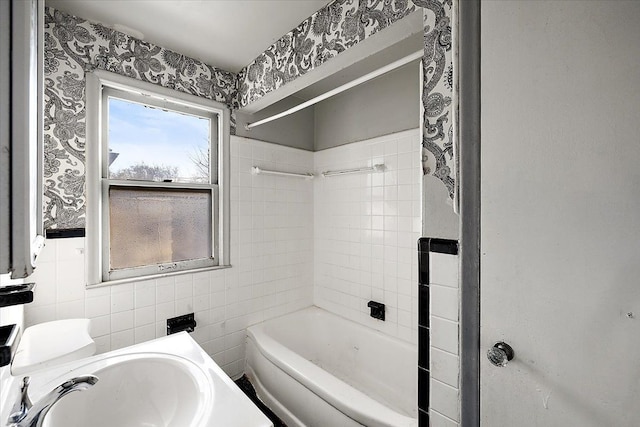 bathroom with tiled shower / bath combo, tile walls, and vanity