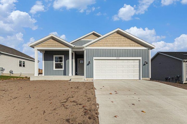 view of front of home with board and batten siding, an attached garage, and driveway