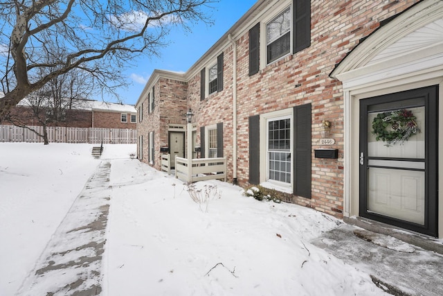 view of snow covered back of property