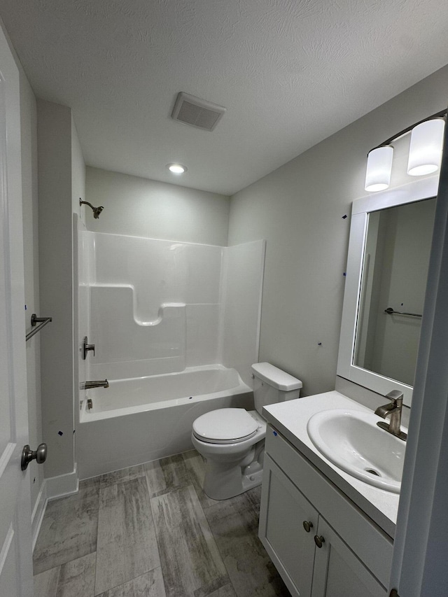273 Hickory Valley Dr, Kalamazoo, MI 49009 - bathroom with toilet, vanity, bathtub / shower combination, a textured ceiling, and wood finished floors