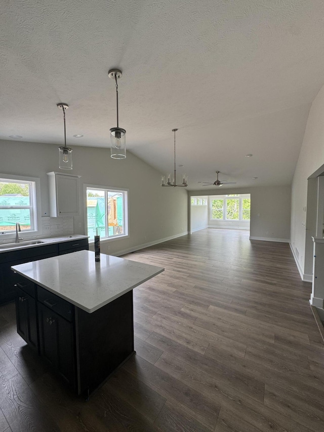 273 Hickory Valley Dr, Kalamazoo, MI 49009 - kitchen with dark cabinetry, a sink, lofted ceiling, open floor plan, and dark wood finished floors