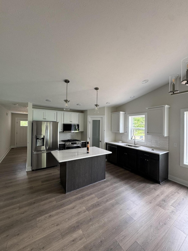273 Hickory Valley Dr, Kalamazoo, MI 49009 - kitchen featuring stainless steel appliances, a sink, a kitchen island, tasteful backsplash, and a textured ceiling