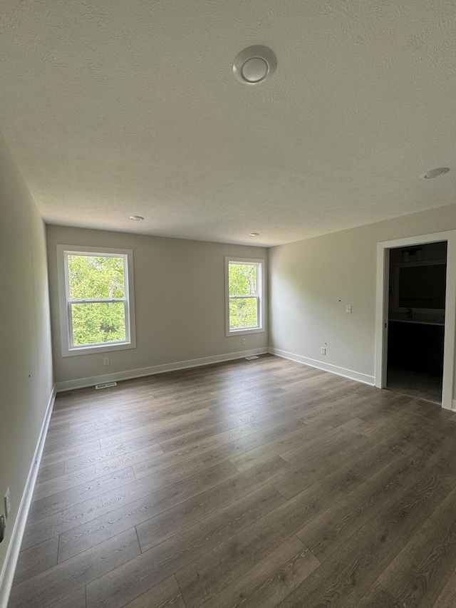 273 Hickory Valley Dr, Kalamazoo, MI 49009 - unfurnished room featuring dark wood-style flooring, baseboards, and a textured ceiling