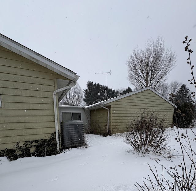 view of snowy exterior with central air condition unit