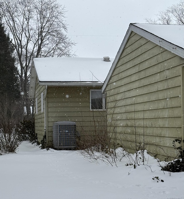 view of snow covered exterior with central AC unit