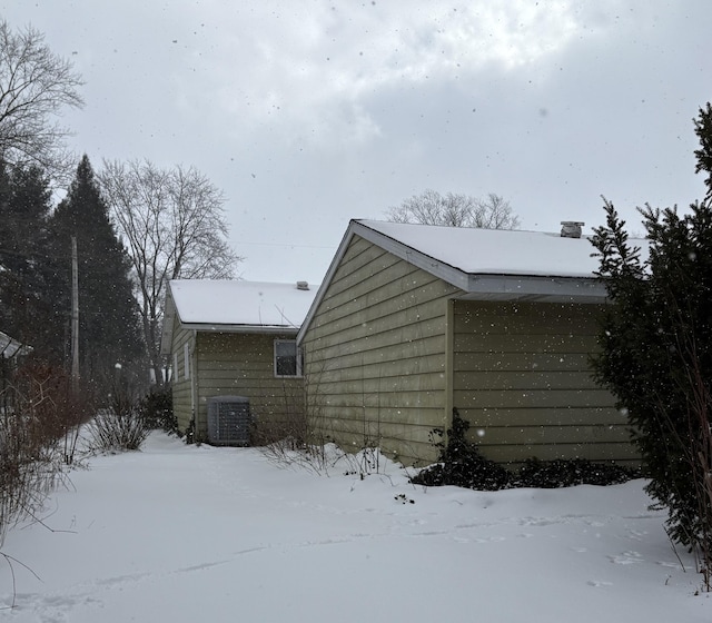 view of snowy exterior featuring central AC unit