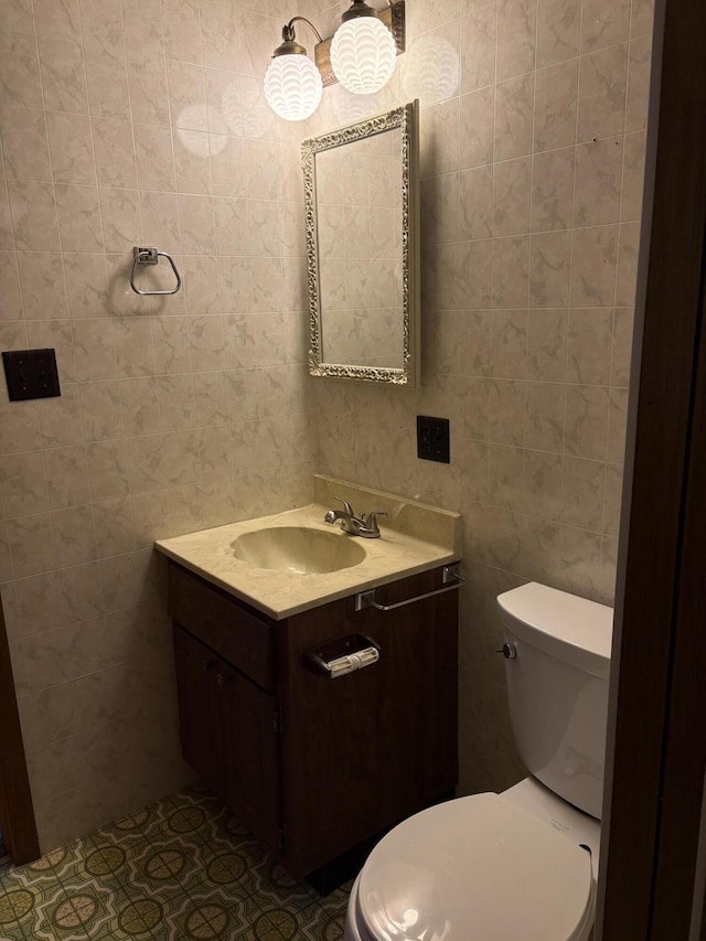 bathroom featuring tile walls, vanity, toilet, and tile patterned floors