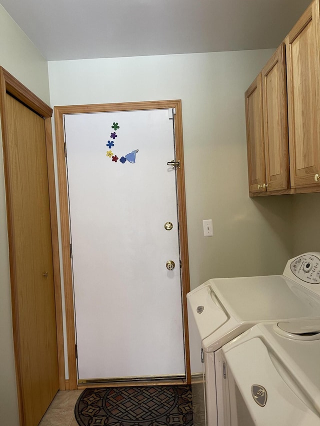 clothes washing area featuring cabinets, light tile patterned floors, and independent washer and dryer