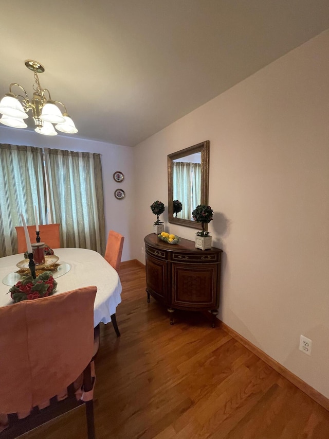 dining space featuring hardwood / wood-style floors and an inviting chandelier