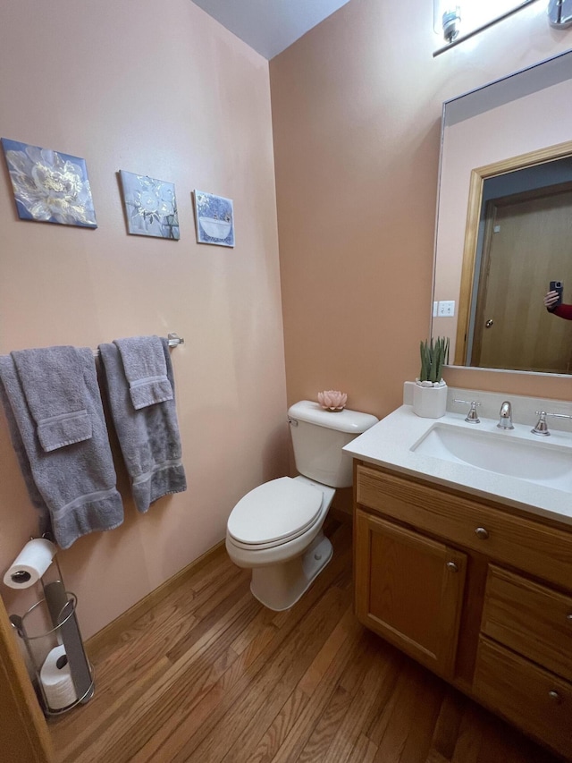 bathroom featuring toilet, hardwood / wood-style flooring, and vanity